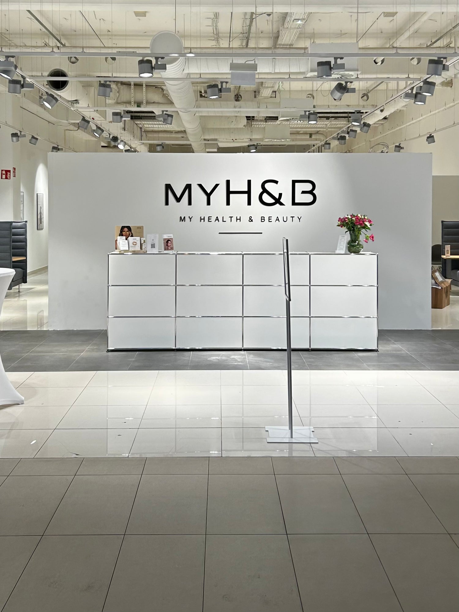 Empfangsbereich bei MYH&B mit weißem Tresen und modernem Interior