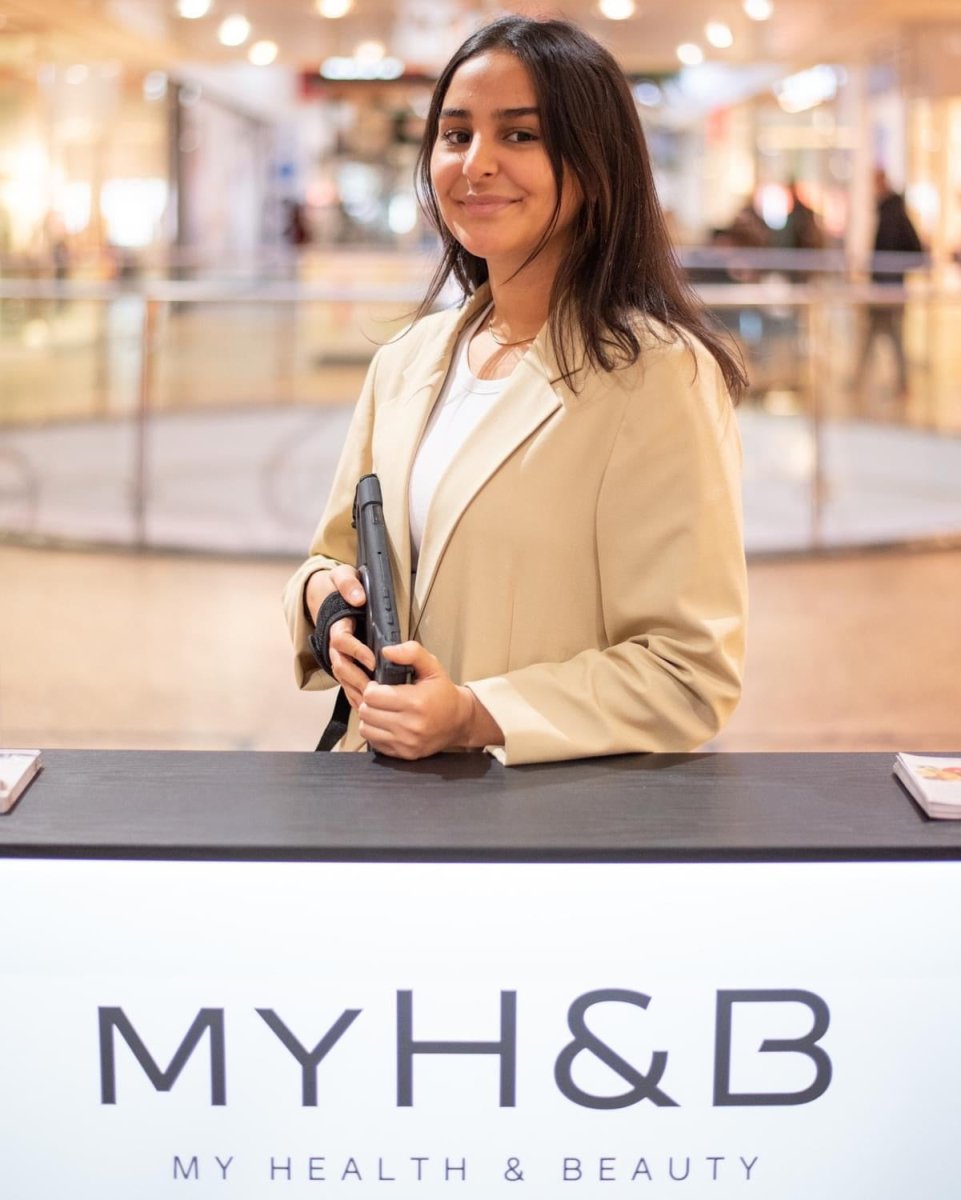 Freundliche Mitarbeiterin von MYH&B am Empfangscounter im Shoppingcenter.