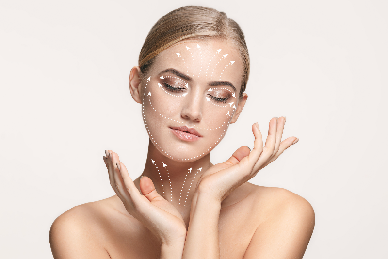 Frau mit eingezeichneten Vektorpfeilen im Gesicht – visuelle Darstellung ästhetischer Gesichtsbehandlung