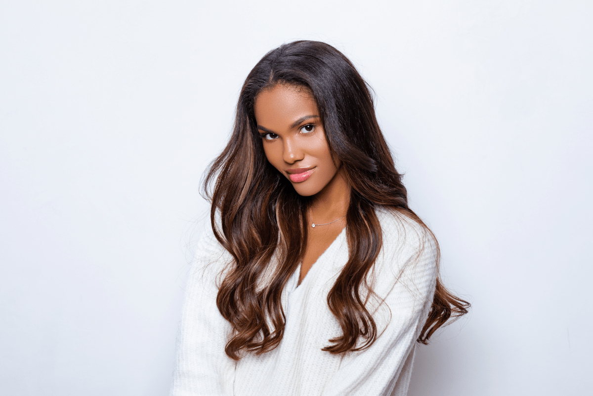 Strahlende Frau mit glänzendem, langem Haar – Ergebnis professioneller Haarpflege oder PRP-Behandlung