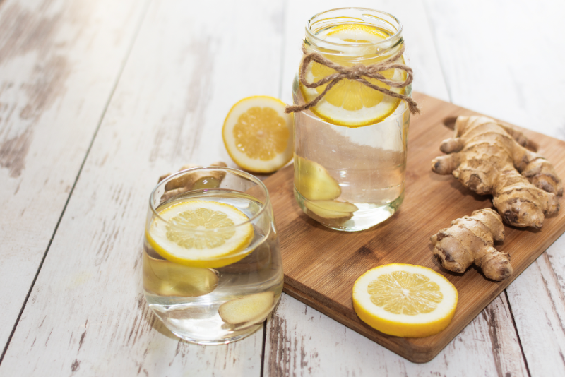 Hausgemachtes Zitronen-Ingwer-Wasser zur Stärkung des Immunsystems, serviert auf Holzbrett