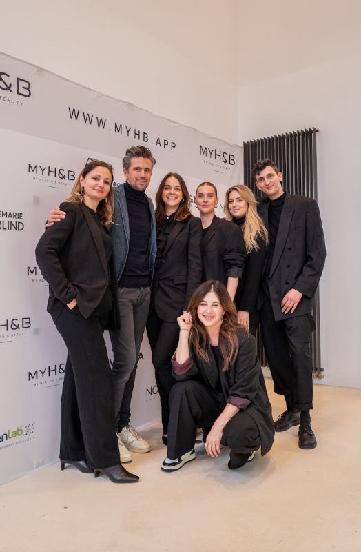 MYH&B Teamfoto mit sieben Personen in dunkler Kleidung vor gebrandetem Event-Hintergrund
