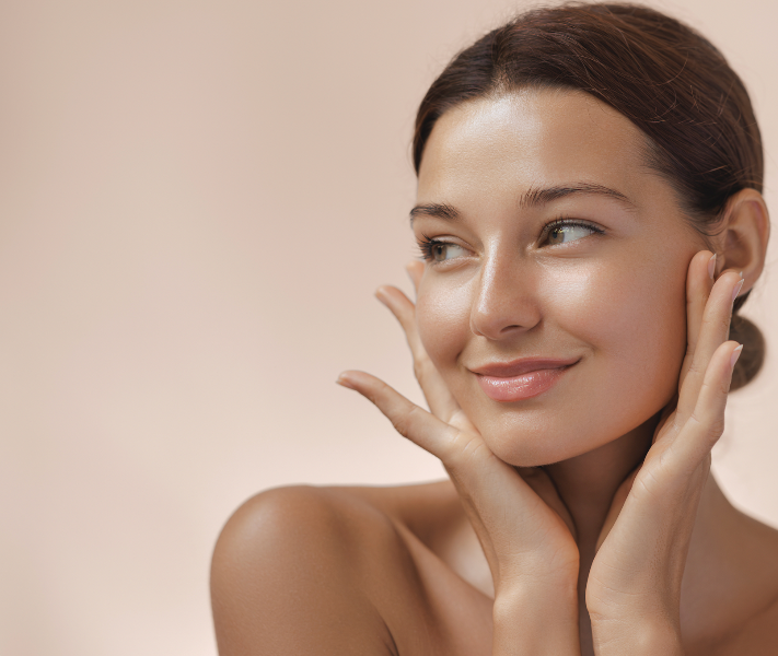 Frau schaut seitlich und berührt sanft ihr Gesicht – Darstellung eines natürlichen Glow-Effekts.