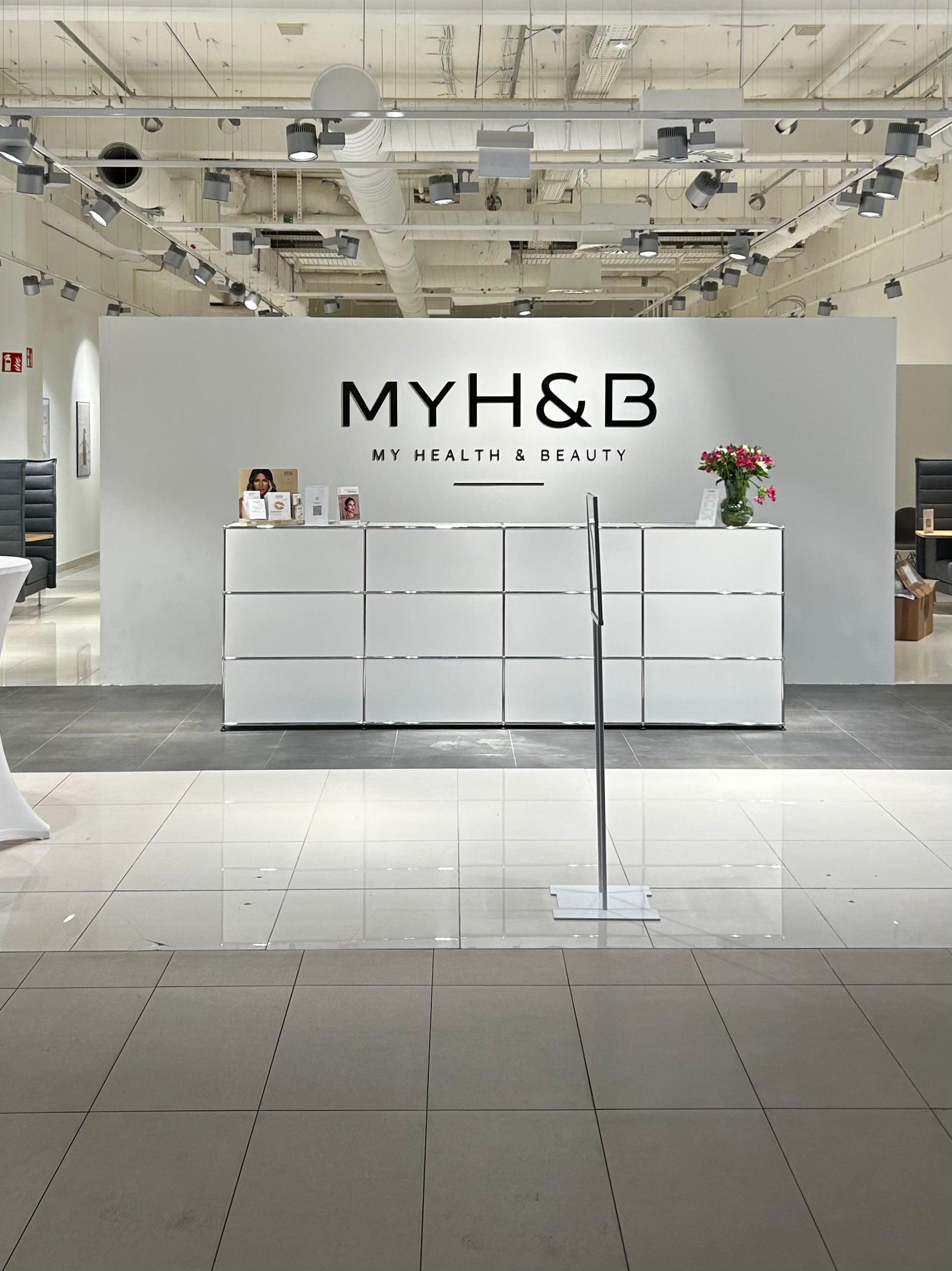 Empfangsbereich bei MYH&B mit weißem Tresen und modernem Interior