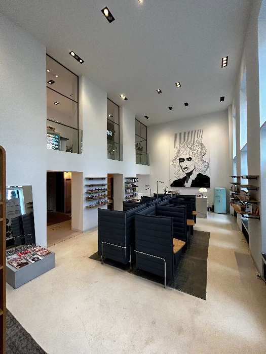 Offener MYH&B Behandlungsraum mit hoher Decke, Kunstporträt und Infusionsplätzen.