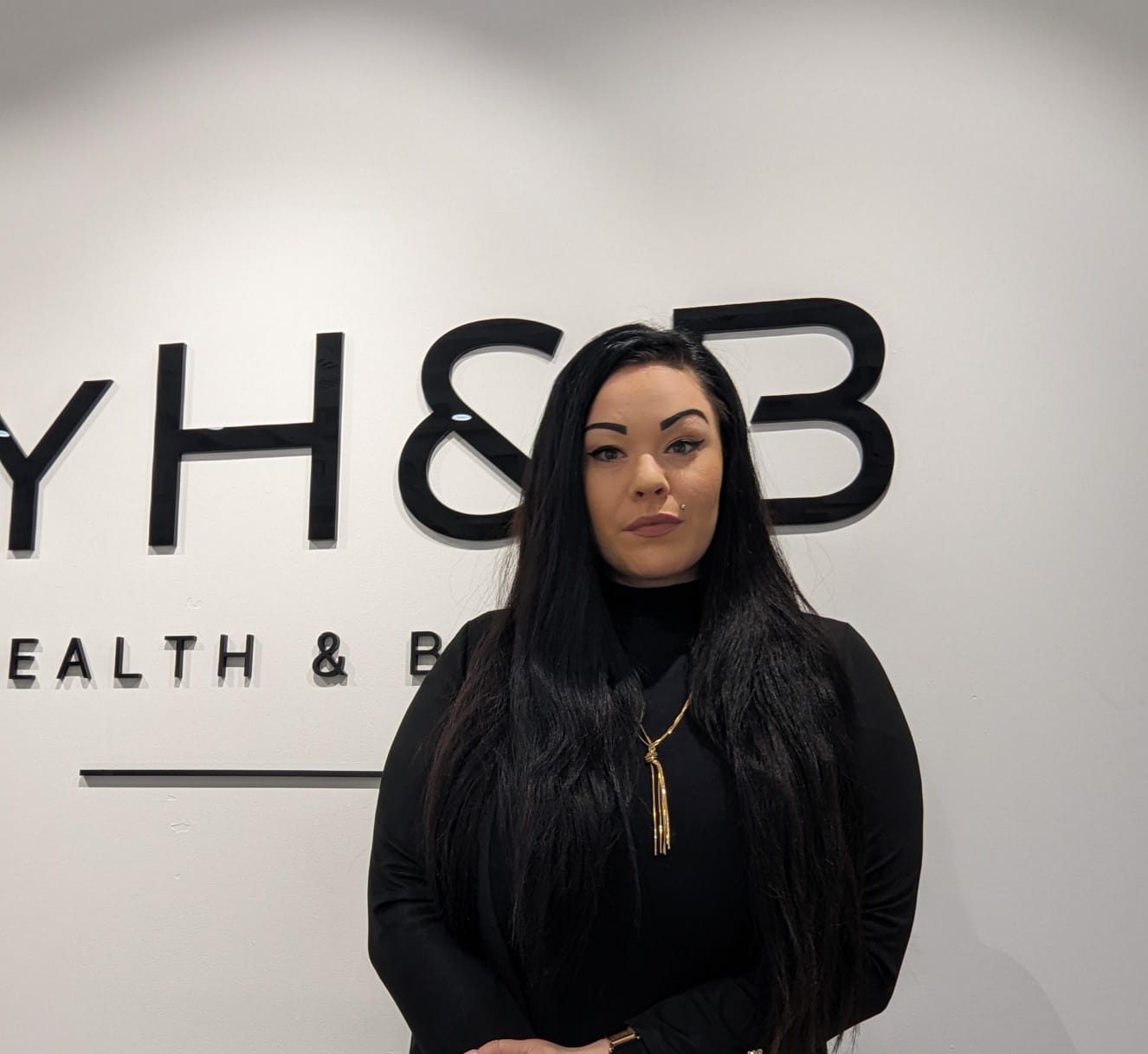 MYH&B Mitarbeiterin mit langen dunklen Haaren – Kundenempfang und Beratung