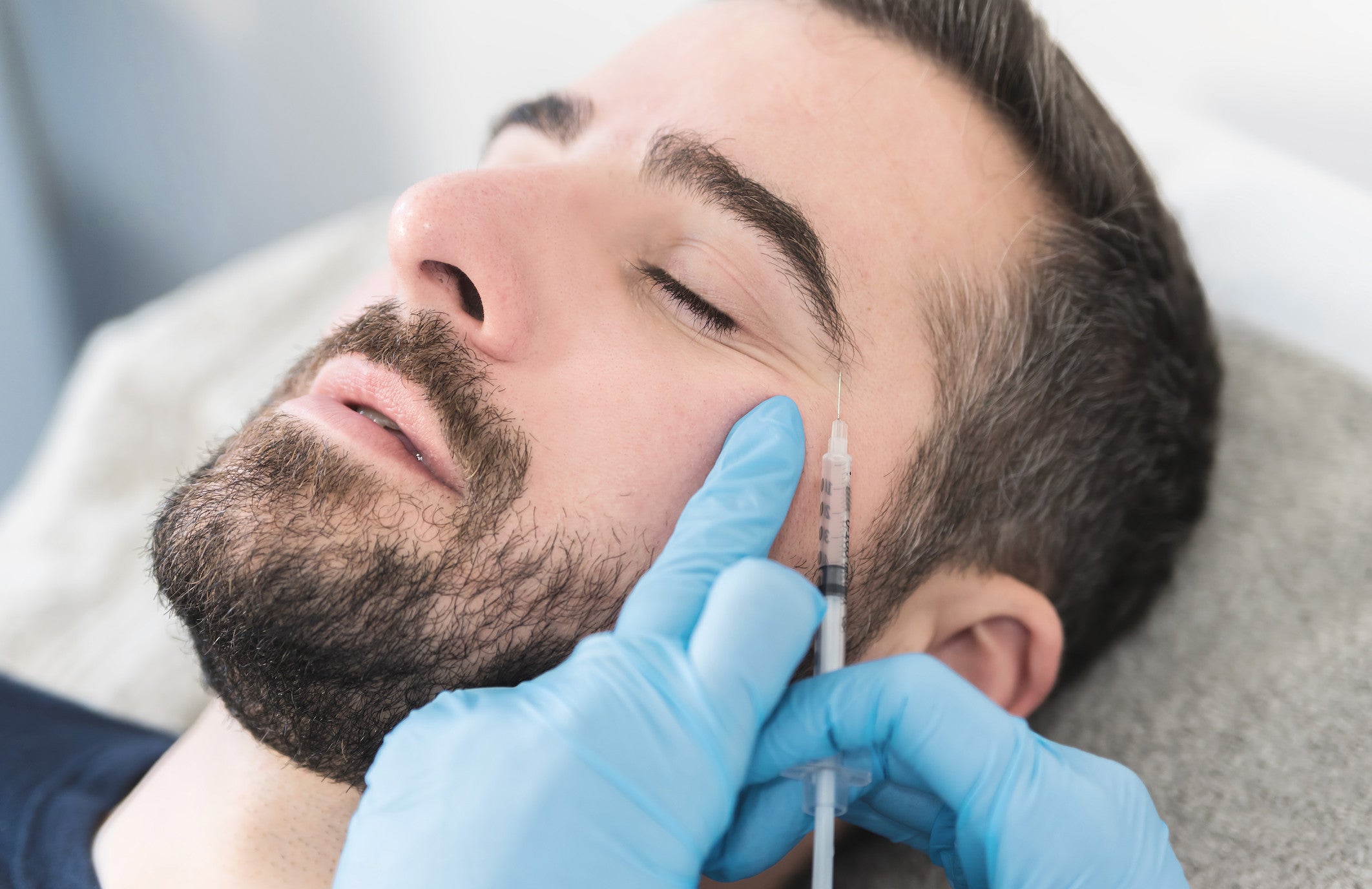Mann erhält Behandlung gegen Krähenfüße im Augenbereich